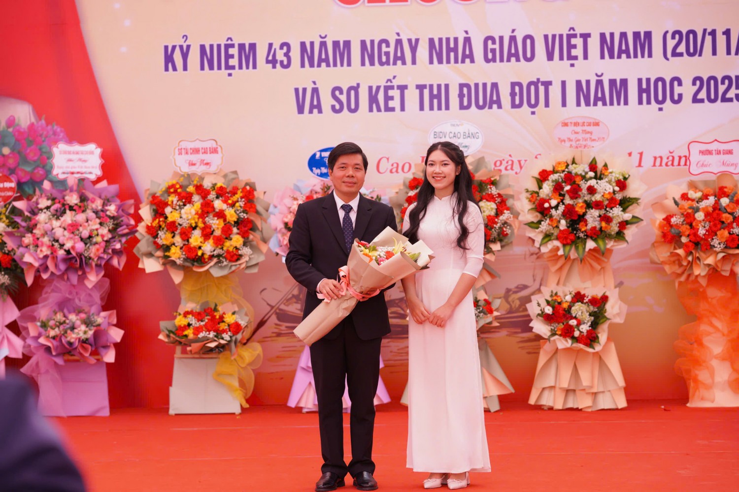 Em Bế Thị Minh Thư - học sinh lớp 12 Văn đại diện cho toàn thể học sinh tặng hoa chúc mừng thầy giáo Hà Tiến Sỹ - Bí thư Đảng bộ, Hiệu trưởng nhà trường